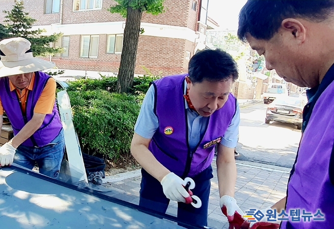 밝은사회 수원클럽이 영통구 관내 산드래미경로당, 방충망 교체 작업을 하고 있다.