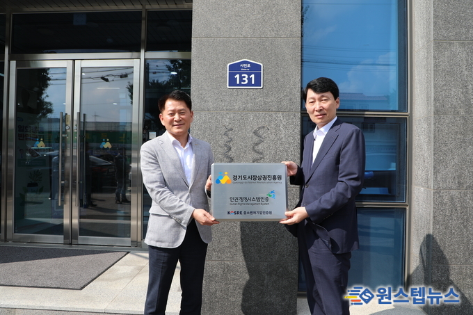 김민철 경기도시장상권진흥원장이 18일 엄진엽 중소벤처기업인증원장과 함께 인권경영시스템 인증 현판식을 진행하고 있다.