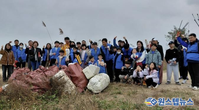 8일 화성시 가족봉사단과 함께하는 자원순환실천 연안정비활동 참가자들이 쓰레기 줍기 활동을 마치고 기념 촬영하고 있다