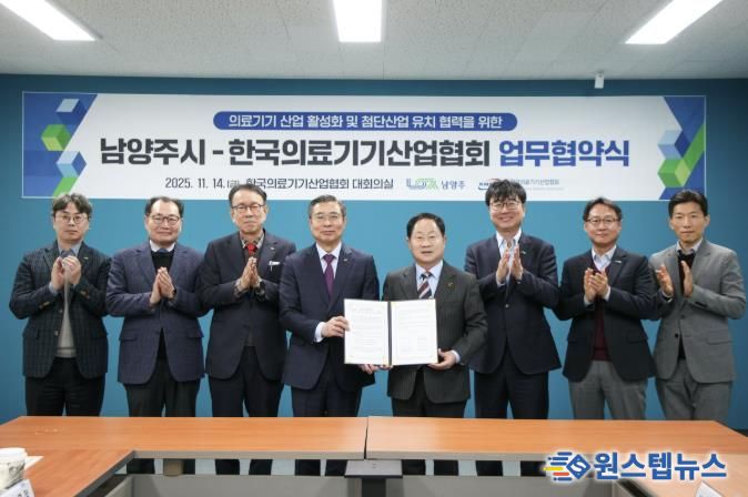 양 측 관계자가 협약서와 함께 단체사진을 촬영하고 있다