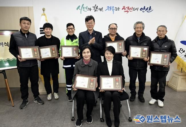 이민근 안산시장(뒷줄 가운데)이 모범시민으로 선정한 환경미화원 8명에게 표창장을 수여하고, 함께 기념촬영을 하고 있다.