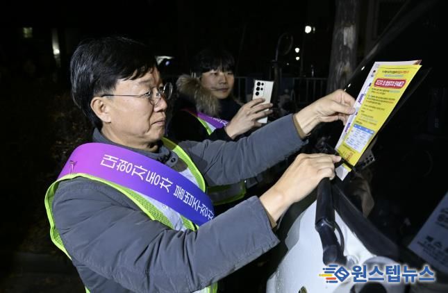 이민근 안산시장이 20일 새벽시간, 단원구 와동 일대에 불법 밤샘주차된 대형차랑에 계도문을 부착하고 있다.