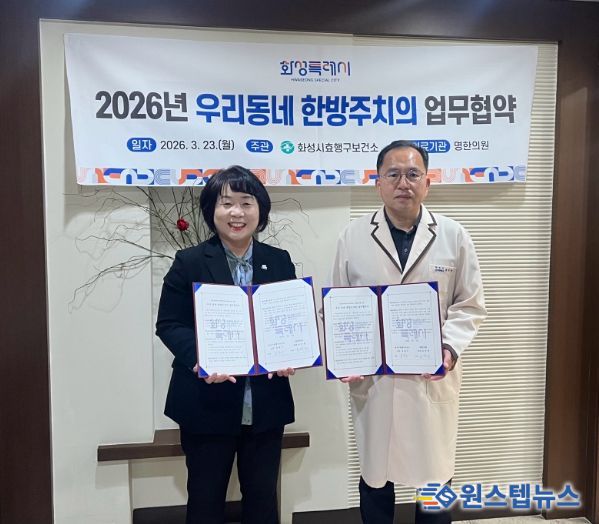 유종우 효행구보건소장과 명한의원 윤탁현 원장이 업무협약을 체결하고 협약서를 들고 기념촬영을 하고 있다